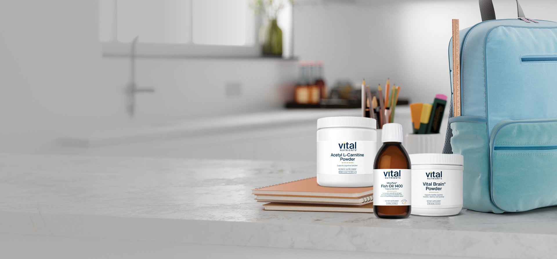 Vital Nutrients supplement products are on a kitchen counter with a blue bag and a notebook.